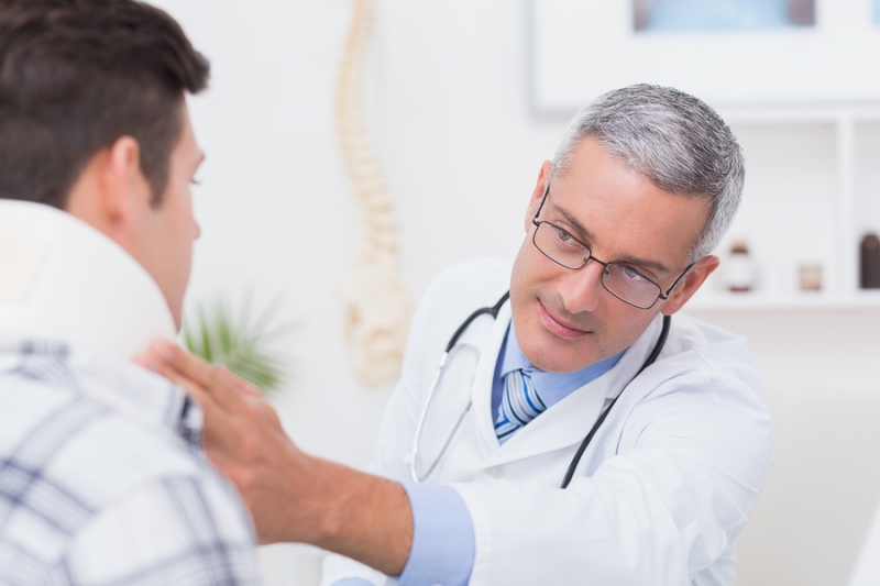 Doctor examining patient wearing neck brace